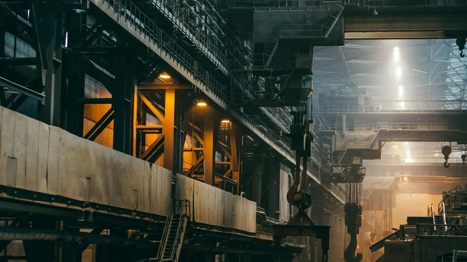Intérieur d'une vaste usine de métallurgie, charpente d'acier et ligne de production vues en perspective