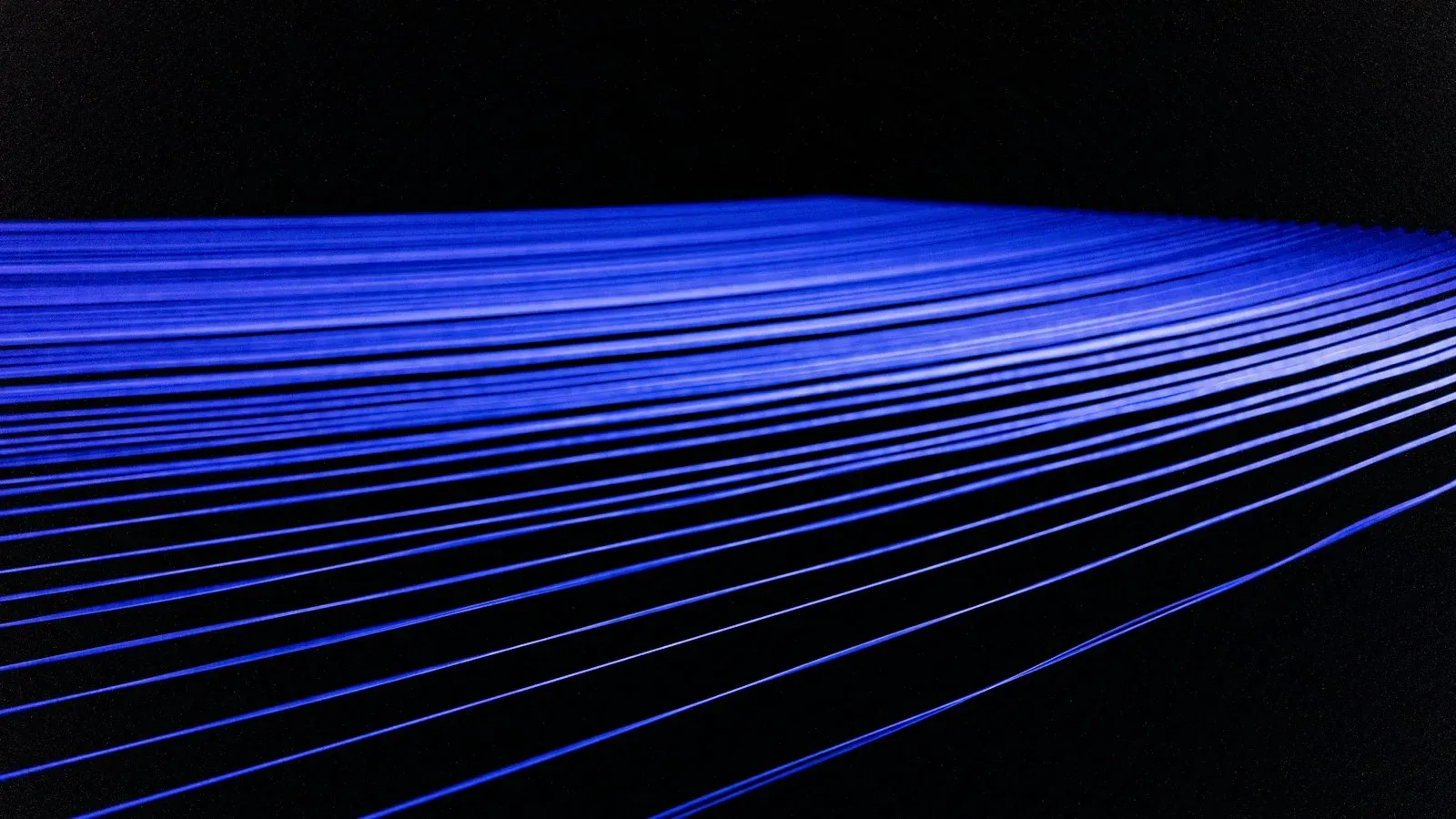 Fines bandes de lumière bleue au centre d’un fond noir, dans une composition minimaliste
